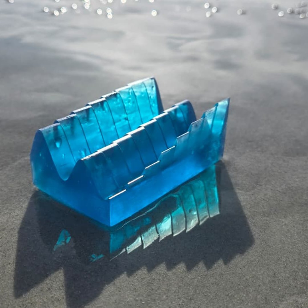 Translucent blue tide keepsake on wet beach sand